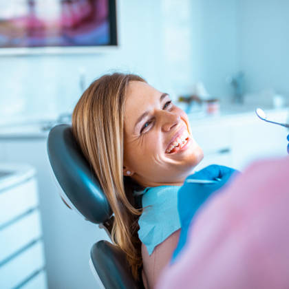 smiling female patient in dentist chair