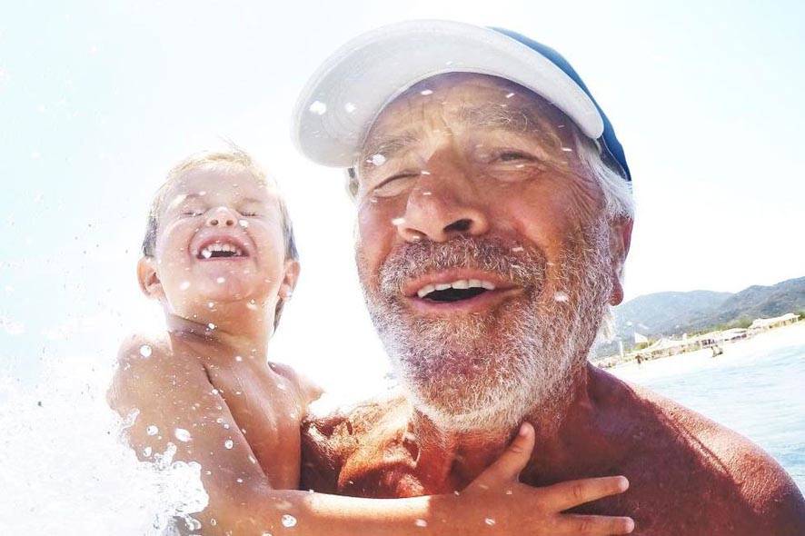 man with child in the surf