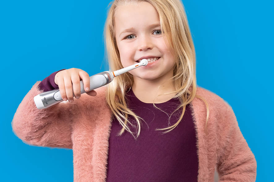 Little girl using an electric toothbrush