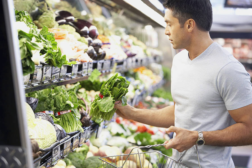 Man in the supermarket shopping for vegetables