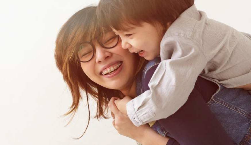 mother giving child a piggyback ride